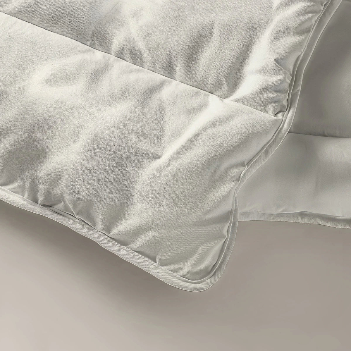 Eine Nahaufnahme der Zelesta Everyday Uni Bettdecke - Creme zeigt die gesteppten Nähte und die weiche Textur, die sie zur perfekten Ganzjahresdecke machen.