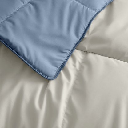 Nahaufnahme einer gesteppten blauen Decke auf einer beigen Bettdecke, beide mit weicher Textur - Zelesta Premiumbed Baumwolle - Dream Blue & Cream, wie geschaffen für ein verwöhnendes Schlaferlebnis.