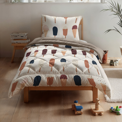 Ein hübsch gemachtes Einzelbett mit dem Zelesta Kiddybed Baumwolle - Gelato und Eiscreme in einem Kinderzimmer, mit Holzboden, Spielzeug und einem Stapel Bücher neben dem Bett.