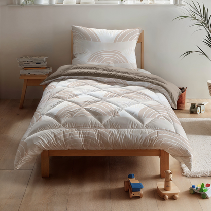 Ein hübsch gemachtes Einzelbett mit dem Zelesta Kiddybed Baumwolle - Dune Dreams und gemusterter Kinderbettwäsche in einem hellen Zimmer, mit Holzspielzeug, Büchern in der Nähe und einer Pflanze auf der Fensterbank.