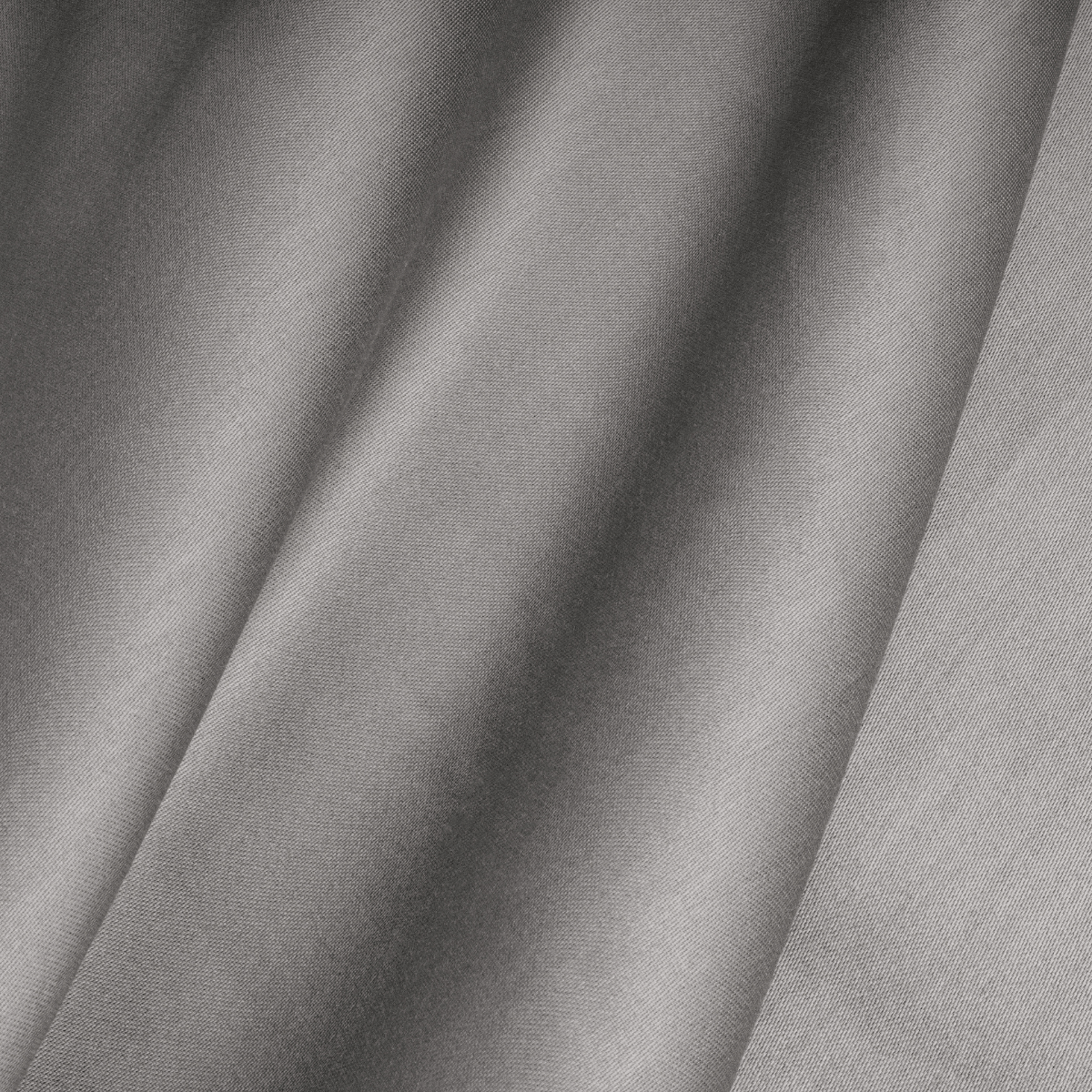Nahaufnahme des grauen Satinstoffs mit sichtbarer Struktur und weichen, diagonalen Falten, wie er im Primaviera Deluxe Topper Satin Deluxe Spannbettuch - Grau zu sehen ist.