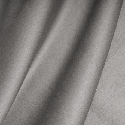 Nahaufnahme des grauen Satinstoffs mit sichtbarer Struktur und weichen, diagonalen Falten, wie er im Primaviera Deluxe Topper Satin Deluxe Spannbettuch - Grau zu sehen ist.