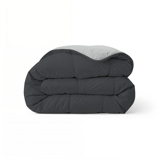Eine sauber gefaltete Zelesta Comfort Duo Bettdecke in sanftem Schwarz & Silbergrau wird vor einem schlichten weißen Hintergrund präsentiert.