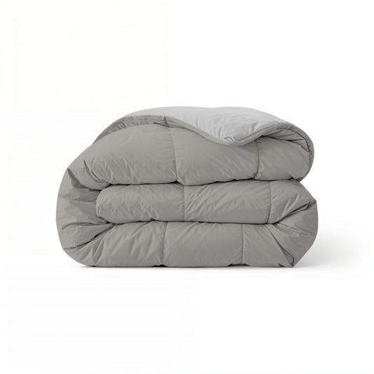 Eine sauber gefaltete Zelesta Comfort Duo Bettdecke in Grau & Sanftes Grau wird vor einem schlichten weißen Hintergrund präsentiert.