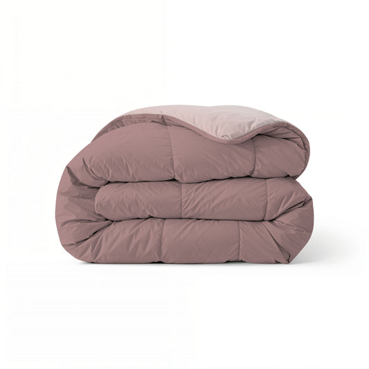 Eine gefaltete, dicke Zelesta Comfort Duo Bettdecke in Rosa- und Hellrosa-Tönen wird vor einem weißen Hintergrund präsentiert.