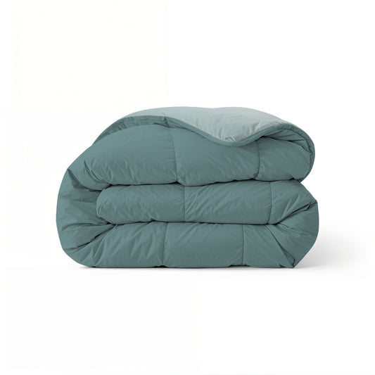 Eine gefaltete Zelesta Comfort Duo Bettdecke in Mineral & Hellblau wird vor einem schlichten weißen Hintergrund präsentiert.