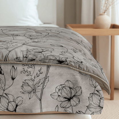 Nahaufnahme eines ordentlich gemachten Bettes mit der grauen, blumengemusterten Bettwäsche und dem Bettkasten von Zelesta Royalbed - Butterfly Forest, neben einem hölzernen Nachttisch mit einer beigen Vase und Dekoration in einem sanft beleuchteten Schlafzimmer.