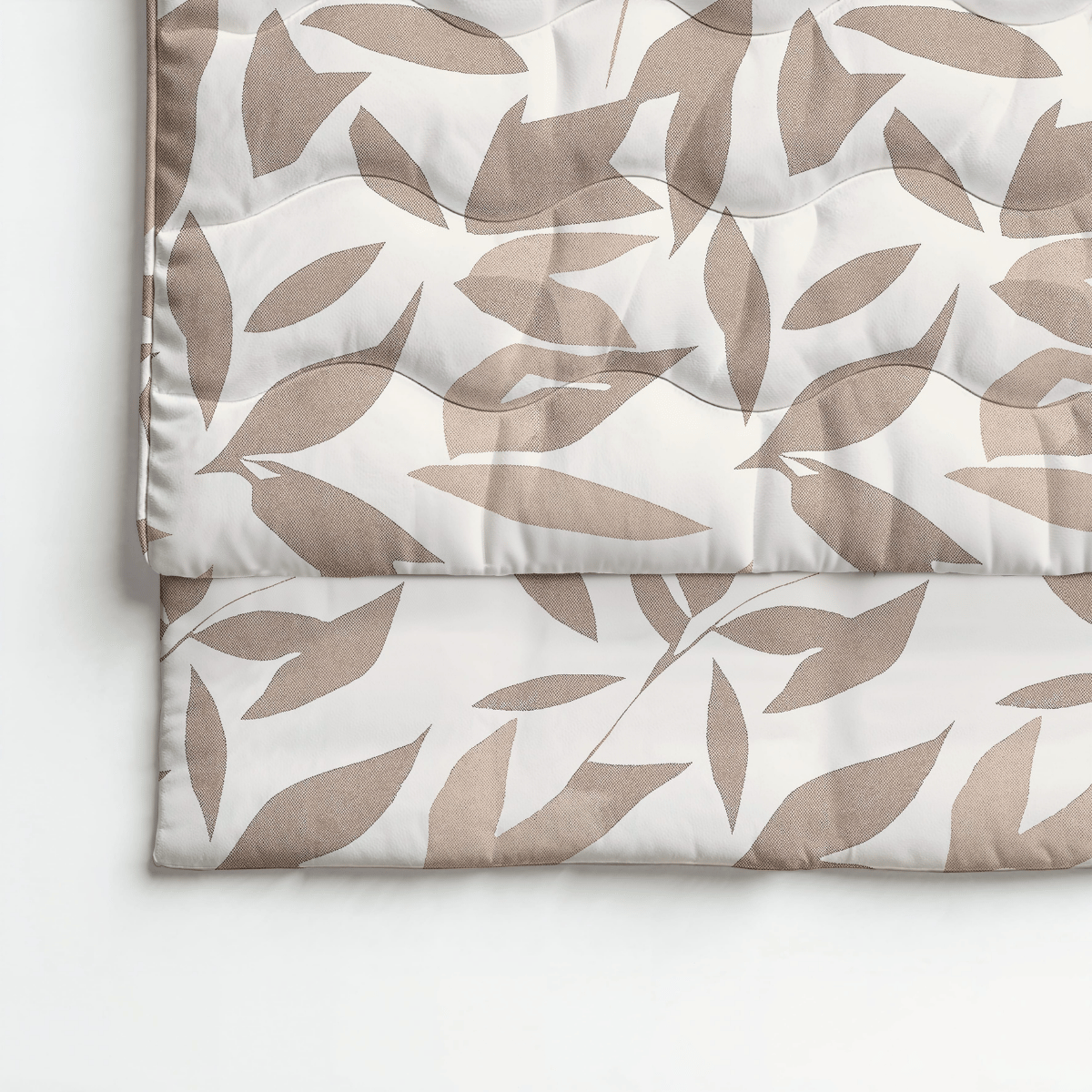Eine gefaltete Royalbed Baumwolle - Beige Autumn Bettdecke mit einem beigen und hellbraunen abstrakten Blattmuster auf Weiß, allergikergeeignet für stilvollen Komfort und erholsame Nächte.