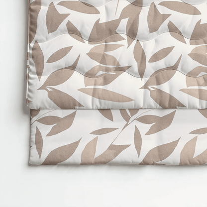 Eine gefaltete Royalbed Baumwolle - Beige Autumn Bettdecke mit einem beigen und hellbraunen abstrakten Blattmuster auf Weiß, allergikergeeignet für stilvollen Komfort und erholsame Nächte.