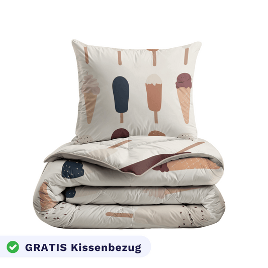 Das Zelesta Kiddybed Baumwolle - Gelato Set besteht aus einer gefalteten Bettdecke und einem Kissen mit Eiscreme- und Eiszapfendruck, Temperaturregulierung Bettwäsche und einem "GRATIS Kissenbezug" Etikett mit einem grünen Häkchen unten links.