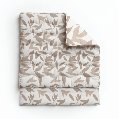 Eine gefaltete Royalbed Baumwolle - Beige Autumn Bettdecke mit einem abstrakten Blattmuster in Beige und Weiß auf weißem Hintergrund. Diese allergikergeeignete Bettdecke bietet stilvollen Komfort für erholsame Nächte.