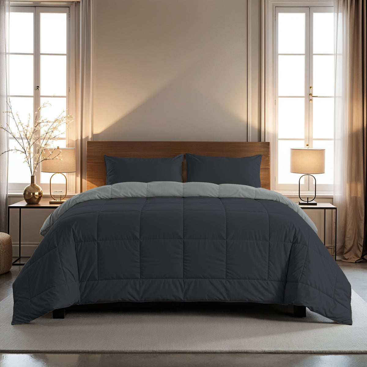 Ein ordentlich gemachtes Bett mit einer dunkelgrauen Bettdecke und Zelesta Comfort Duo Kissenbezüge Set von 2 - Sanftes Schwarz (80x80cm) in weicher Mikrofaser, flankiert von Fenstern, Nachttischen, Lampen und Dekoration in einem modernen, neutral getönten Schlafzimmer.