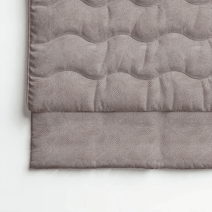 Eine Nahaufnahme der Royalbed Baumwolle - Brown Animal Steppdecke, die ein dezentes Tiermuster in Brauntönen zeigt und auf einer hellen Oberfläche gefaltet ist - perfekt für alle, die eine allergikergeeignete Bettwarenoption suchen.