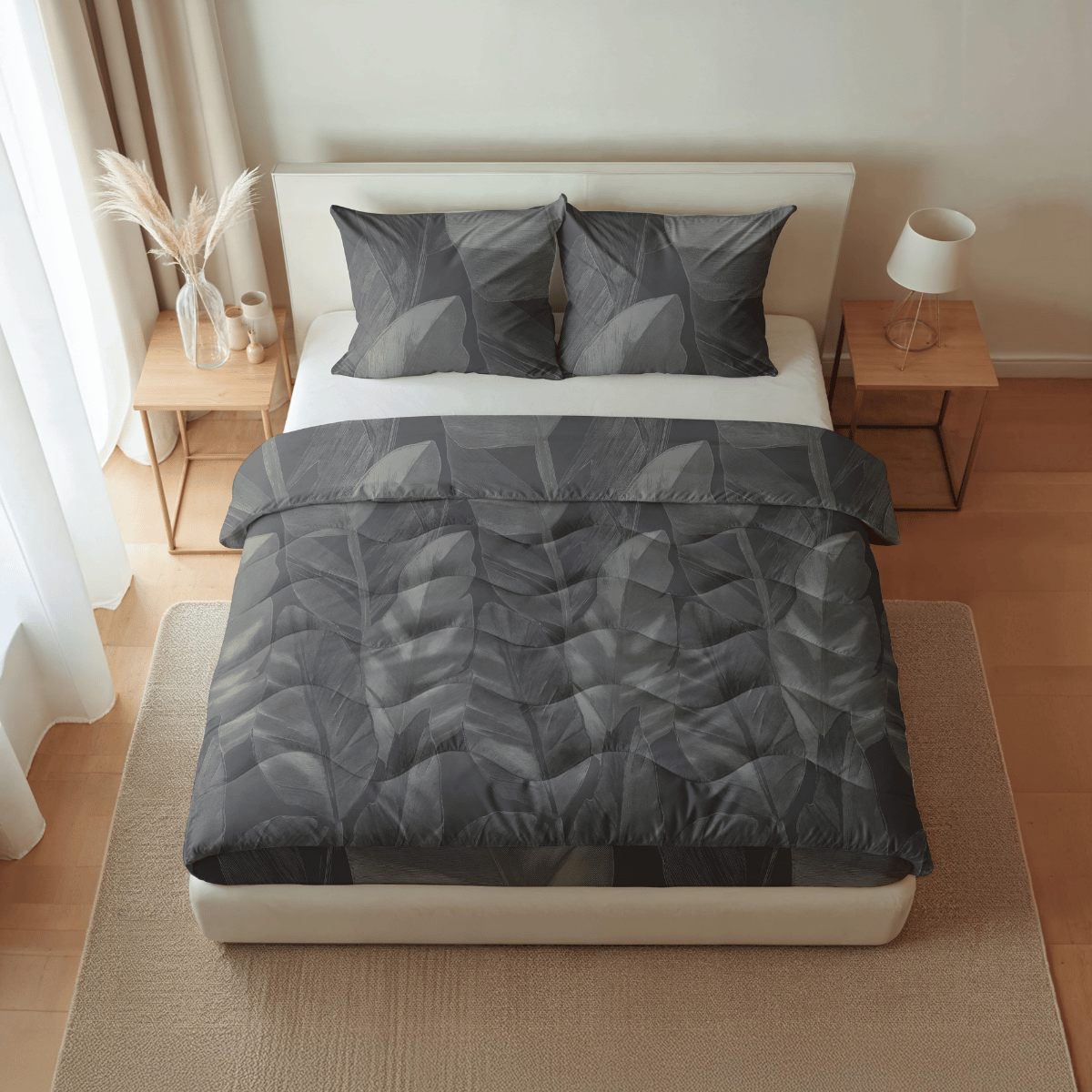 Ein ordentlich gemachtes Bett mit der Royalbed Baumwolle - Black Swan grauen, blattgemusterten, allergikerfreundlichen Bettdecke und passenden Kissen, flankiert von zwei hölzernen Nachttischen in einem minimalistischen, gut beleuchteten Schlafzimmer.