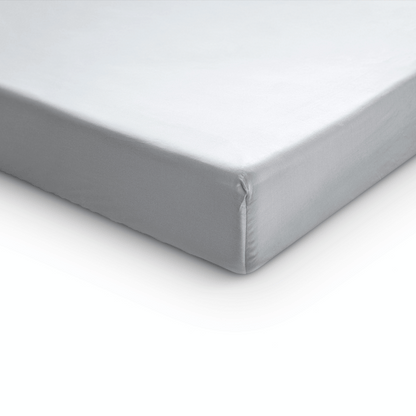 Nahaufnahme einer Matratzenecke, auf der das Primaviera Deluxe Topper Satin Deluxe Spannbettuch in Weiß glatt aufgelegt ist, vor einem weißen Hintergrund.