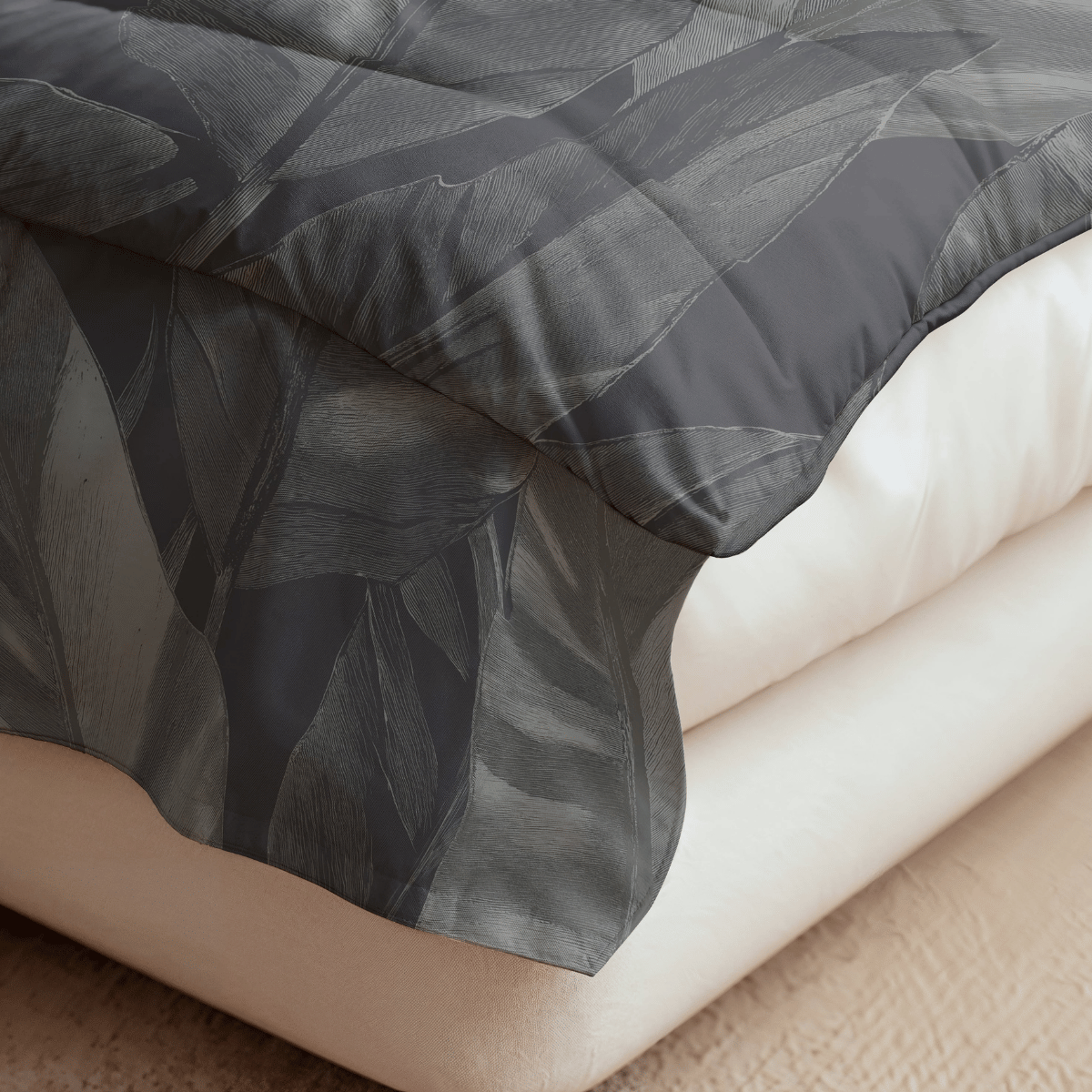 Nahaufnahme eines Bettes mit cremefarbener Matratze und der dunkelgrauen Bettdecke Royalbed Baumwolle - Black Swan mit dezentem Blattmuster, die elegant über den Rand drapiert ist.