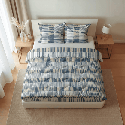 Ein ordentlich gemachtes Bett mit blau-weiß gestreifter Bettwäsche, zwei passenden Kissen und hölzernen Nachttischen auf beiden Seiten kennzeichnet die Royalbed Baumwolle - Checkerboard temperaturregulierende Bettdecke, von oben gesehen.