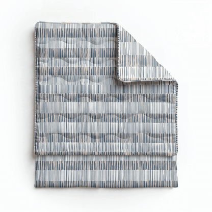 Die Royalbed Baumwolle - Checkerboard ist eine allergikerfreundliche Bettdecke mit geometrischem Muster in Grau, Blau und Beige, gefaltet auf weißem Hintergrund präsentiert.