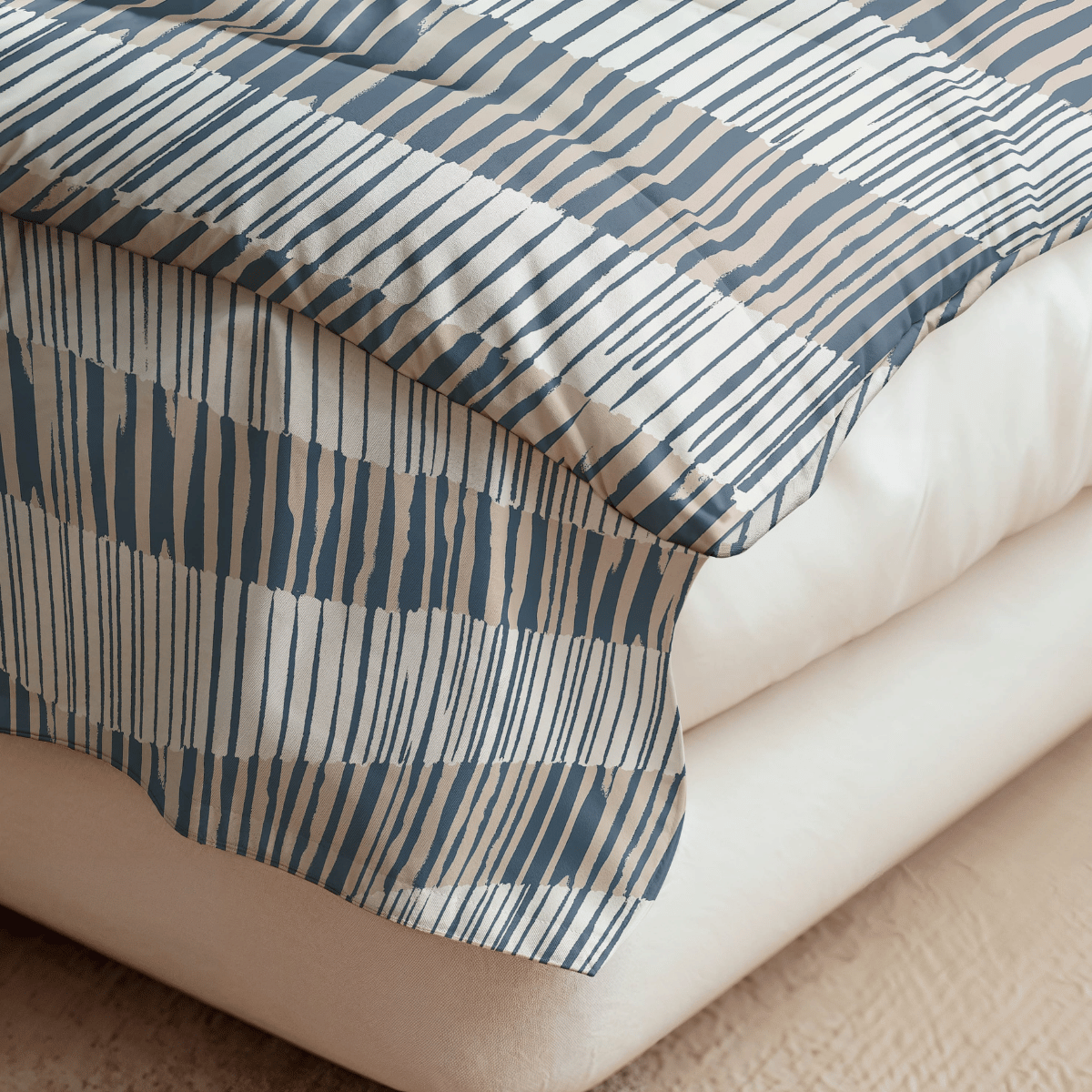Eine Nahaufnahme einer Bettecke mit weißer Bettwäsche und einer blau-beige gestreiften Decke auf hellem Teppich, mit der temperaturregulierenden Royalbed Baumwolle - Checkerboard Bettdecke für zusätzlichen Komfort.