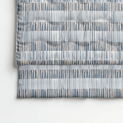 Eine gefaltete Royalbed Baumwolle - Checkerboard Bettdecke mit geometrischem Schachbrettmuster in Blau-, Beige- und Weißtönen und dezenter Wellensteppung.
