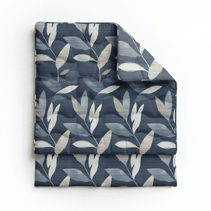 Die Royalbed Baumwolle - Dark Leaves Bettdecke zeichnet sich durch einen marineblauen Hintergrund mit beigen und weißen Blattmustern aus; ideal für Komfort und geeignet für Allergiker.