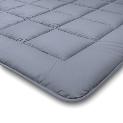Eine Nahaufnahme der Zelesta Comfort Duo Bettdecke in Eisblau und Zartblau mit quadratischen Steppnähten auf weißem Hintergrund.