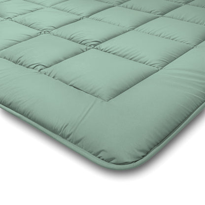 Nahaufnahme der Zelesta Comfort Duo Bettdecke in Mintgrün und Hellgrün mit quadratischen Steppnähten und gepolsterten Bereichen für mehr Komfort und Halt.