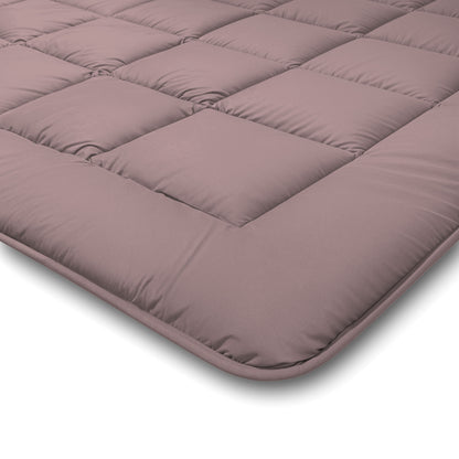 Eine Nahaufnahme der gesteppten Zelesta Comfort Duo Bettdecke in Rosa und Hellrosa mit Gittermuster und weicher, gepolsterter Oberfläche.
