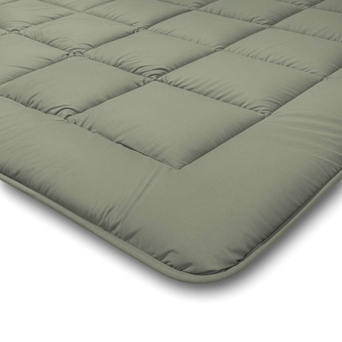 Eine Nahaufnahme der Zelesta Comfort Duo Bettdecke in Olivgrün und Creme mit einem Steppmuster mit quadratischen Nähten auf weißem Hintergrund.