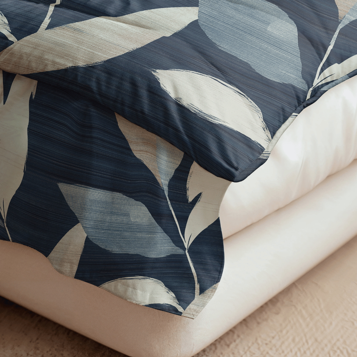 Eine Nahaufnahme eines Bettes mit der Royalbed Baumwolle - Dark Leaves, mit einer beigen Bettdecke unter einem dunkelblauen und beigen Bettbezug mit Blättermuster auf einem strukturierten beigen Teppich; ideal als allergikergeeignete Baumwolle Bettdecke.
