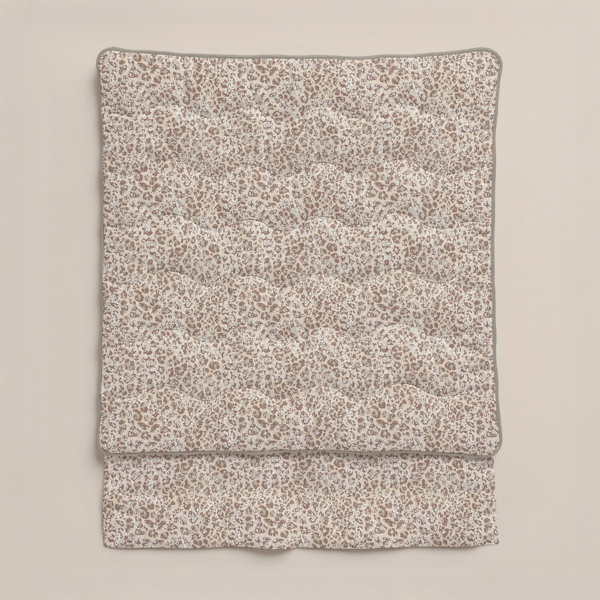 Die Zelesta Royalbed - Sand Panther Bettdecke mit beige-braunem Leopardenmuster aus Mikrofaser Bettdecke ist vor einem einfarbigen, hellen Hintergrund gefaltet.