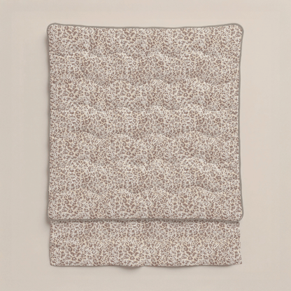 Die Zelesta Royalbed - Sand Panther Bettdecke mit beige-braunem Leopardenmuster aus Mikrofaser Bettdecke ist vor einem einfarbigen, hellen Hintergrund gefaltet.