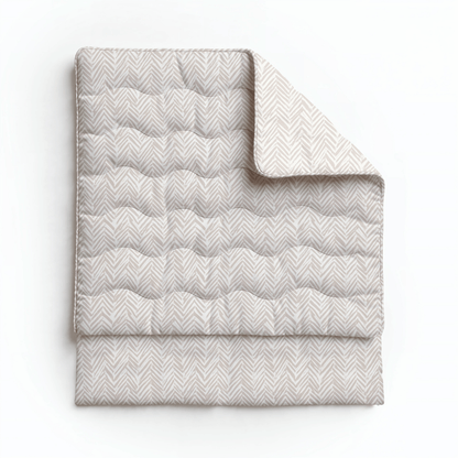 Eine gefaltete, helle Royalbed Baumwolle - Ethnic Cream Bettdecke mit dezentem Chevron-Muster, die auf einem schlichten weißen Hintergrund abgebildet ist.