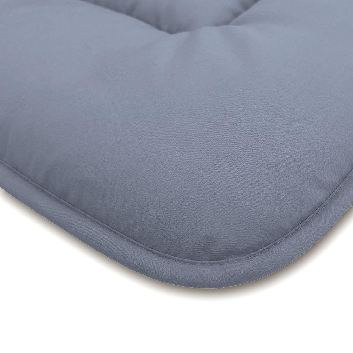 Nahaufnahme einer hellgrauen gepolsterten Oberfläche mit abgerundeten Kanten und sichtbaren Randnähten, die an die Zelesta Comfort Duo Bettdecke in Eisblau & Sanftes Blau erinnert.
