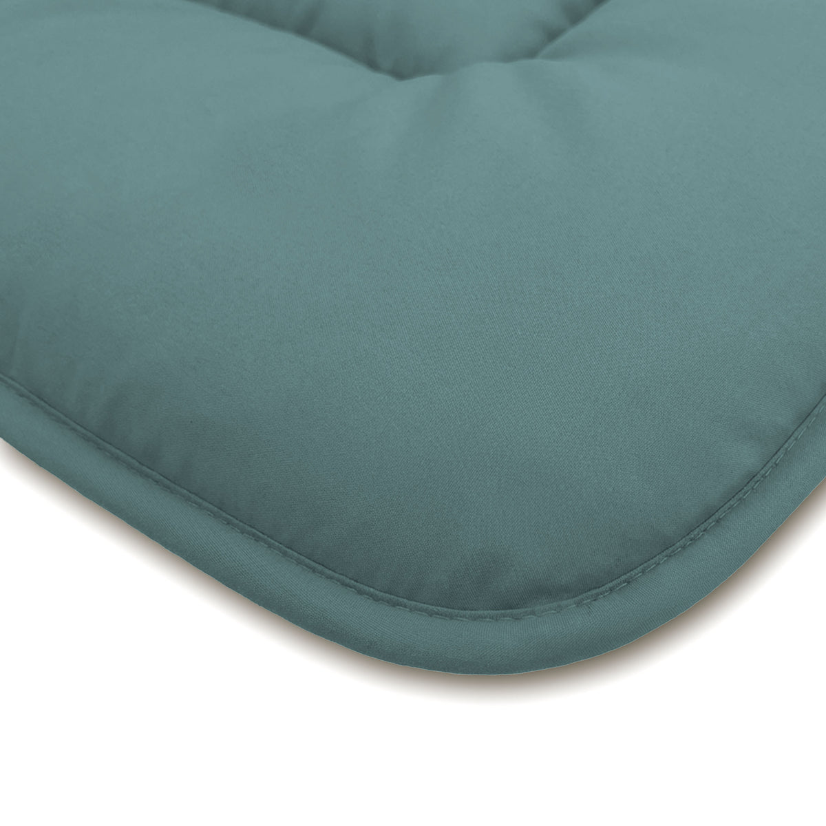 Nahaufnahme eines tealfarbenen rechteckigen Kissens mit abgesteppten Kanten und einer weichen, gepolsterten Oberfläche, die an die Zelesta Comfort Duo Bettdecke - Mineral & Hellblau für ganzjährigen Komfort erinnert.