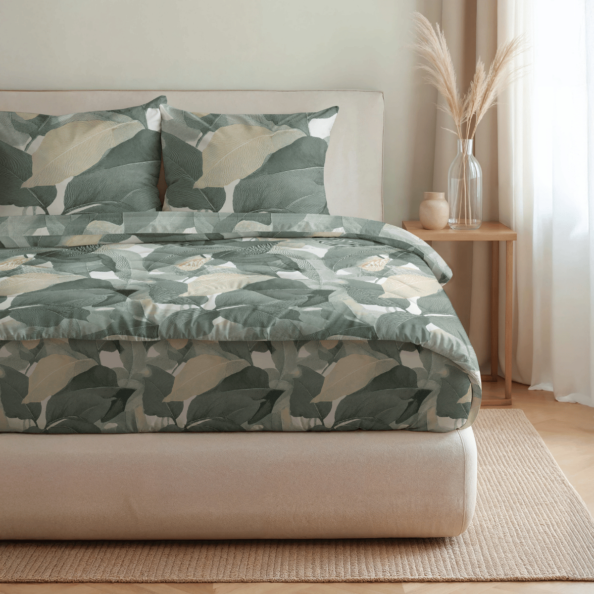 Ein ordentlich gemachtes Bett mit der Royalbed Baumwolle - Green Forest blattgemusterten Bettwäsche und Kissen, sowie ein hölzerner Nachttisch mit Pampasgras in einem sanft beleuchteten Raum, alles ergänzt durch eine allergikergeeignete Bettdecke für zusätzlichen Komfort.