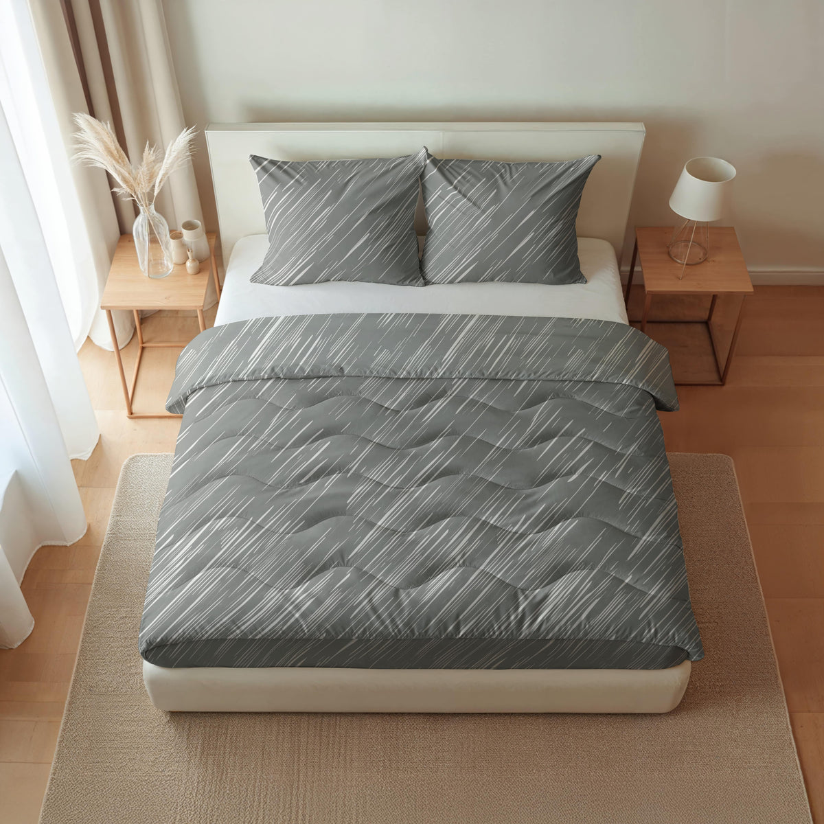 Ein ordentlich gemachtes Bett mit grau gemusterter Bettwäsche, ausgestattet mit der temperaturregulierenden und allergikerfreundlichen Royalbed Baumwolle - Mellow Stone Bettdecke, flankiert von hölzernen Nachttischen mit einer Lampe und Dekor in einem hellen, minimalistischen Schlafzimmer.