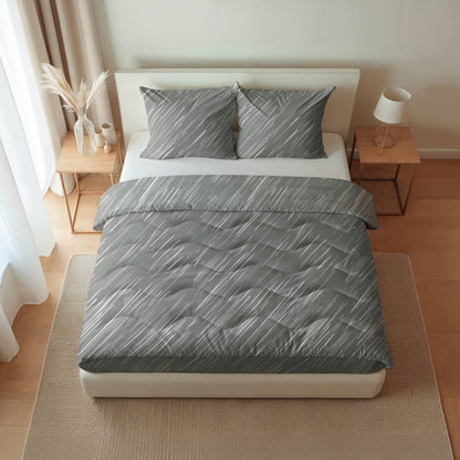 Ein ordentlich gemachtes Bett mit grau gemusterter Bettwäsche, ausgestattet mit der temperaturregulierenden und allergikerfreundlichen Royalbed Baumwolle - Mellow Stone Bettdecke, flankiert von hölzernen Nachttischen mit einer Lampe und Dekor in einem hellen, minimalistischen Schlafzimmer.