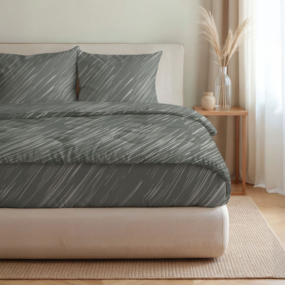 Ein ordentlich gemachtes Bett mit Royalbed Baumwolle - Mellow Stone Bettwäsche in grauen und weißen diagonalen Linien, zwei Kissen, sowie ein Nachttisch mit einer Vase mit getrocknetem Gras und einem kleinen Keramikgefäß.