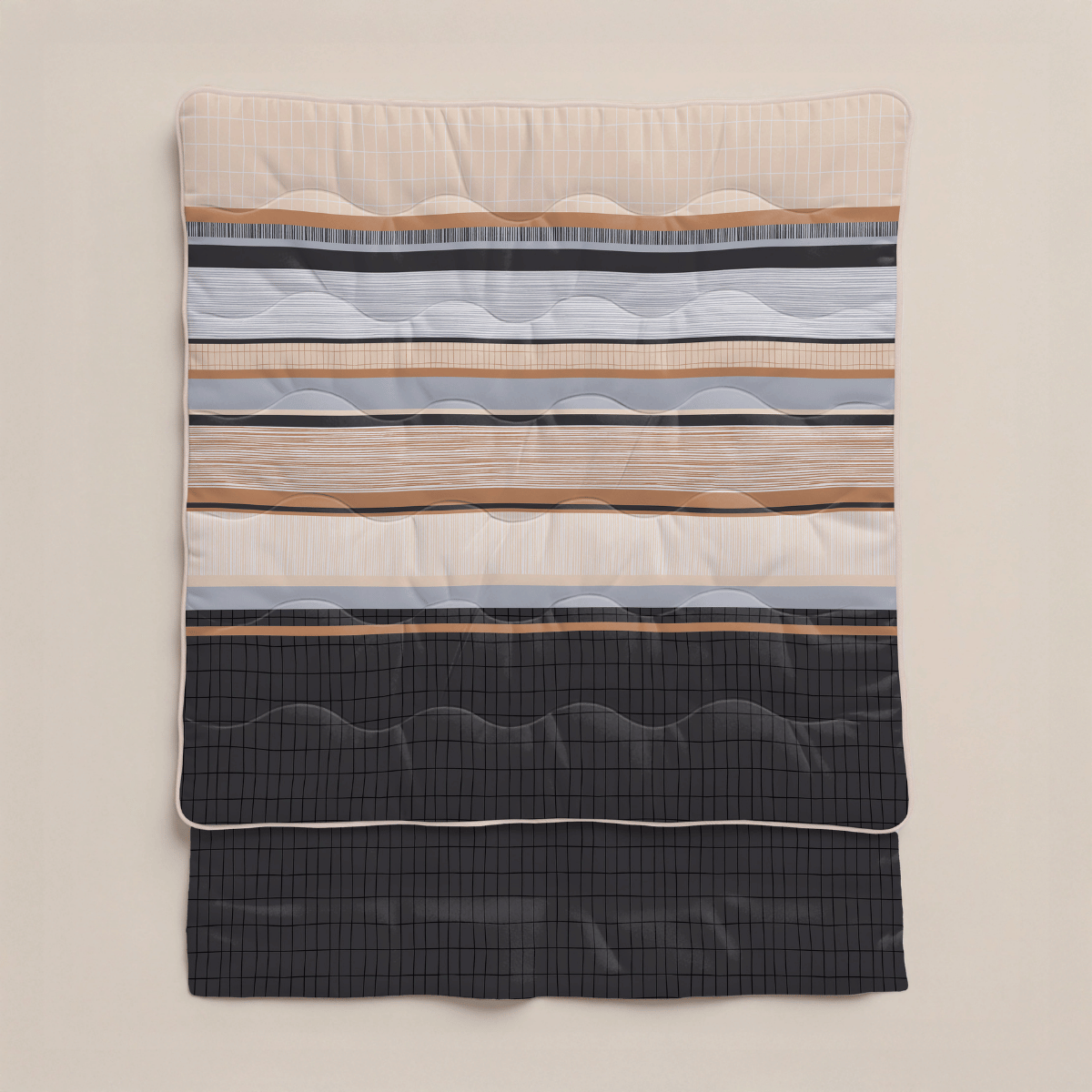 Die Zelesta Royalbed - Blue Stripes Bettdecke zeigt horizontale Streifen in Beige, Grau, Marine und Schwarz mit Wellensteppung und einem schmalen weißen Rand - diese Mikrofaser Bettdecke verspricht dauerhaften Komfort und wird vor einem unifarbenen Hintergrund gezeigt.
