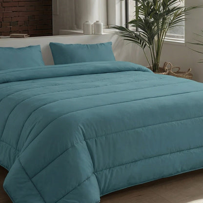 Ein ordentlich gemachtes Bett mit einer tealfarbenen Bettdecke und Zelesta Comfort Uni Kissenbezüge Set von 2 in Seegrün (80x80cm), aufgestellt in der Nähe eines Fensters mit einer Topfpflanze und dekorativen Gläsern auf der Fensterbank.