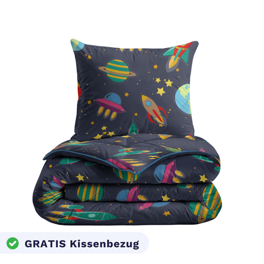 Das Zelesta Kiddybed - Space Dream Bettwäscheset zeigt ein Weltraum-Motiv mit Planeten, Raketen und Sternen auf dunklem Hintergrund. Sie ist waschbar und enthält einen GRATIS Kissenbezug.