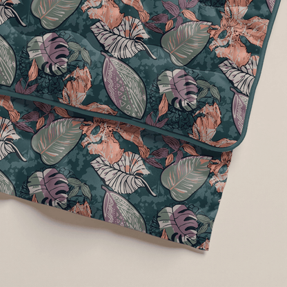 Das Zelesta Royalbed - Flower Power ist eine gesteppte Mikrofaser-Bettdecke mit illustrierten Blättern und Blumen in Grün, Rosa und Beige auf einem dunkelgrünem Hintergrund.