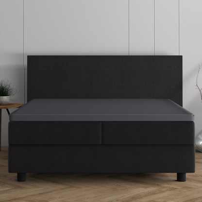 Ein modernes schwarzes Polsterbett mit hohem Kopfteil wertet jeden Raum auf - in Kombination mit dem Doppel Jersey Topper Spannbettlaken in Grau sorgt es für zusätzlichen Komfort. Ideal für die entspannende Atmosphäre in Ihrem Dreamhouse, besonders vor hellen Wänden und Holzböden.