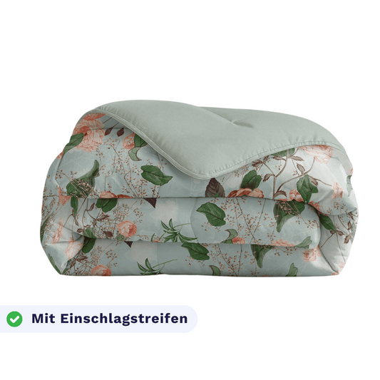 Eine gefaltete Zelesta Royalbed - Happy Flower Bettdecke mit floralem Muster und hellgrüner Rückseite. Ein Etikett unten links zeigt "Mit Einschlagstreifen" neben einem Häkchen.