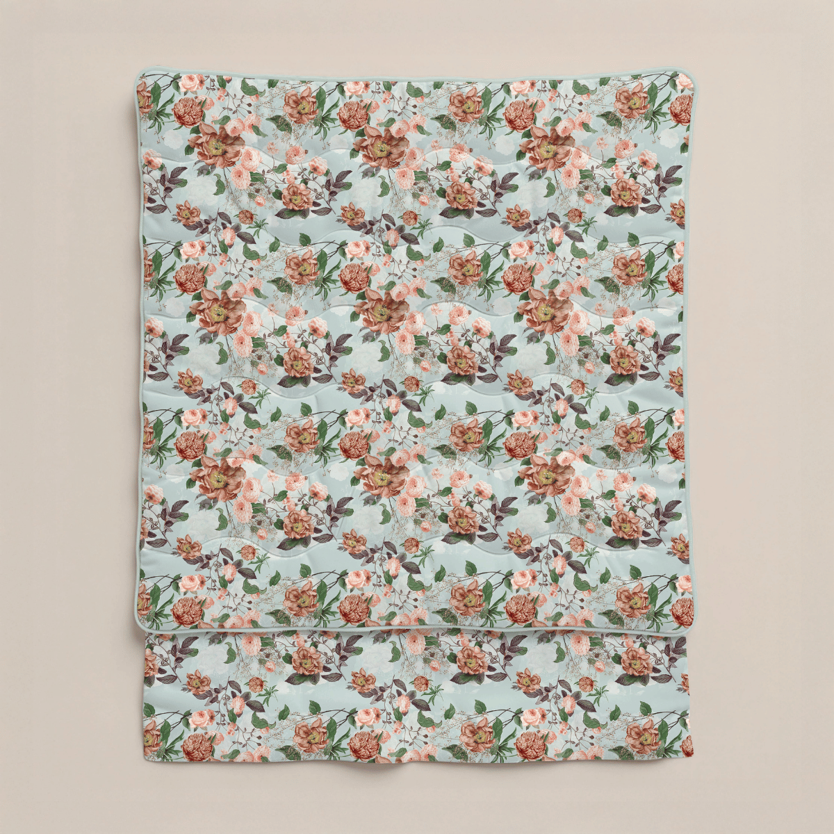Eine gefaltete Zelesta Royalbed - Happy Flower Mikrofaser Bettdecke in Hellblau mit einem sich wiederholenden floralen Muster aus rosa, burgunderroten und weißen Blüten sowie grünen Blättern auf neutralem Hintergrund.