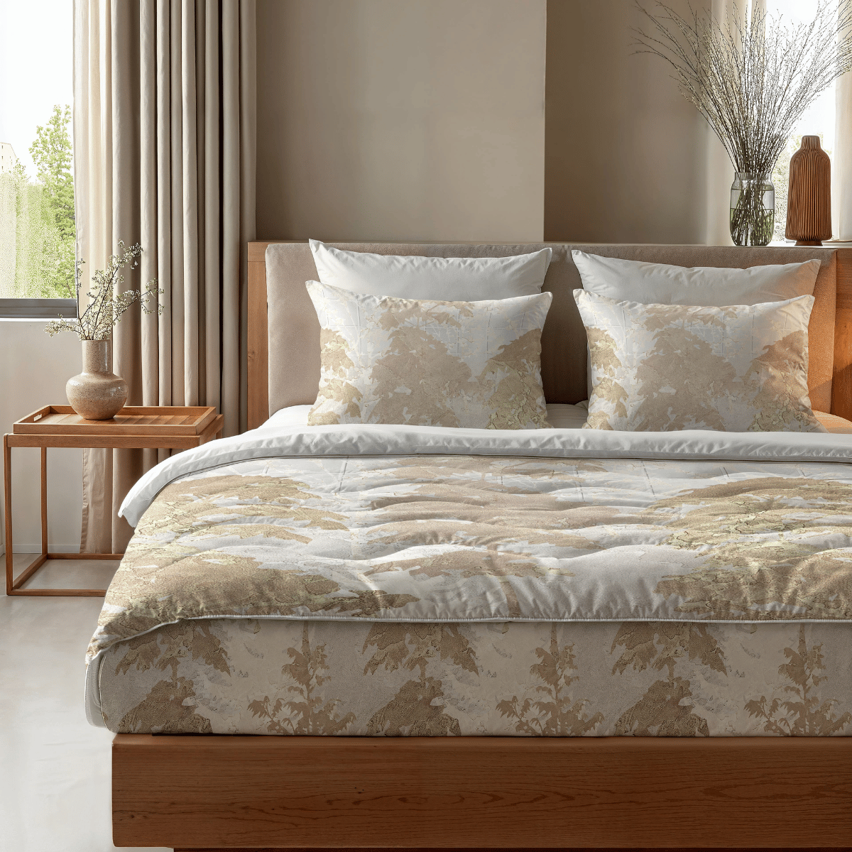 Ein ordentlich gemachtes Bett mit der Zelesta Royalbed - Japanese Tree antiallergische Bettdecke in beige-weißem Muster, vier Kissen, einem hölzernen Kopfteil und einem Nachttisch mit einer Vase und Zweigen, beleuchtet von Licht aus den verdunkelten Fenstern.