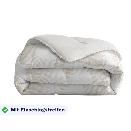 Gefaltete Zelesta Royalbed - Oak Leafs Mikrofaser Bettdecke mit einem weiß-beigen Muster, einem Häkchen-Symbol und "Mit Einschlagstreifen" in der unteren linken Ecke.