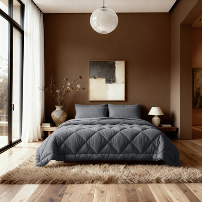 Ein modernes Schlafzimmer mit einem grauen Steppbett mit dem Zelesta Royalbed Diamant - Anthrazit, abstrakter Wandkunst, einer Vase mit getrockneten Zweigen, einer Tischlampe und einem Zottelteppich auf Holzboden. Große Fenster füllen den Raum mit natürlichem Licht.