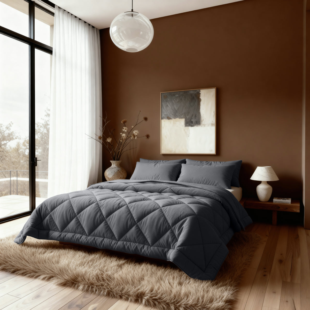 Modernes Schlafzimmer mit der Bettdecke Zelesta Royalbed Diamant - Anthrazit, einem großen Fenster mit weißen Vorhängen, einer braunen Akzentwand, abstrakter Kunst und einem Nachttisch mit Lampe und Vase - ideal für Allergiker und zur Temperaturregelung.